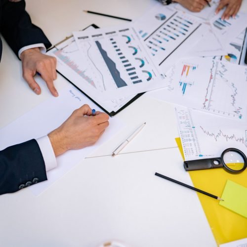 Close-up of a desk cluttered with financial charts, graphs, and reports, perfect for business and finance themes.